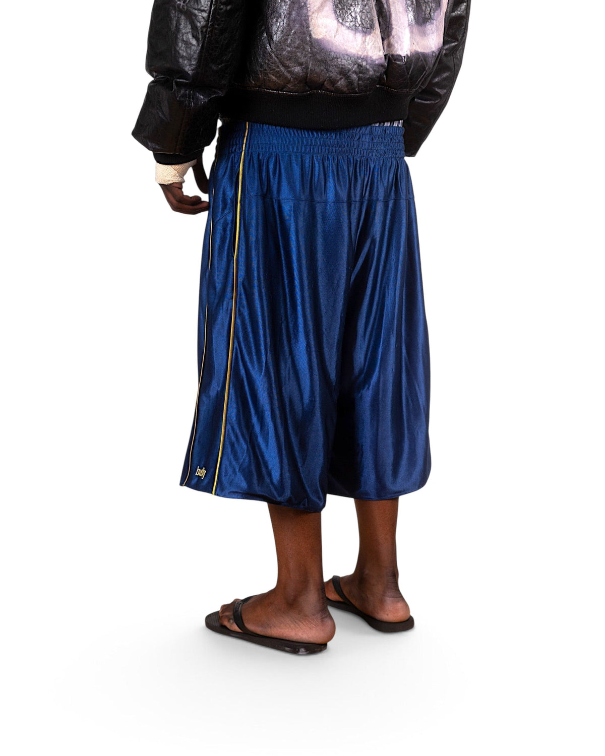 BULLY LA navy raschel knit polyester shorts with yellow contrast piping and side pockets, worn by a male model.